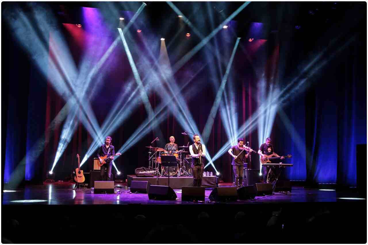 Group playing guitars and creating musical harmony in stage